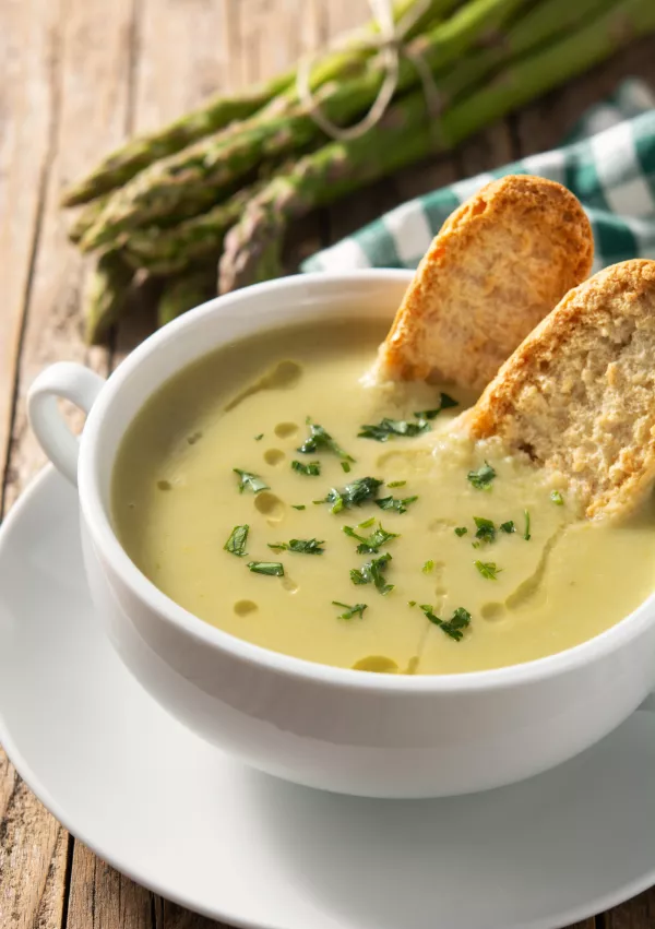 Fresh green asparagus soup in bowl on wooden table. / Foto: Etorres69