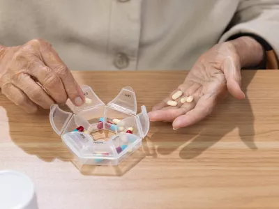 Elderly woman putting pills into pill box for the week. / Foto: Toa55
