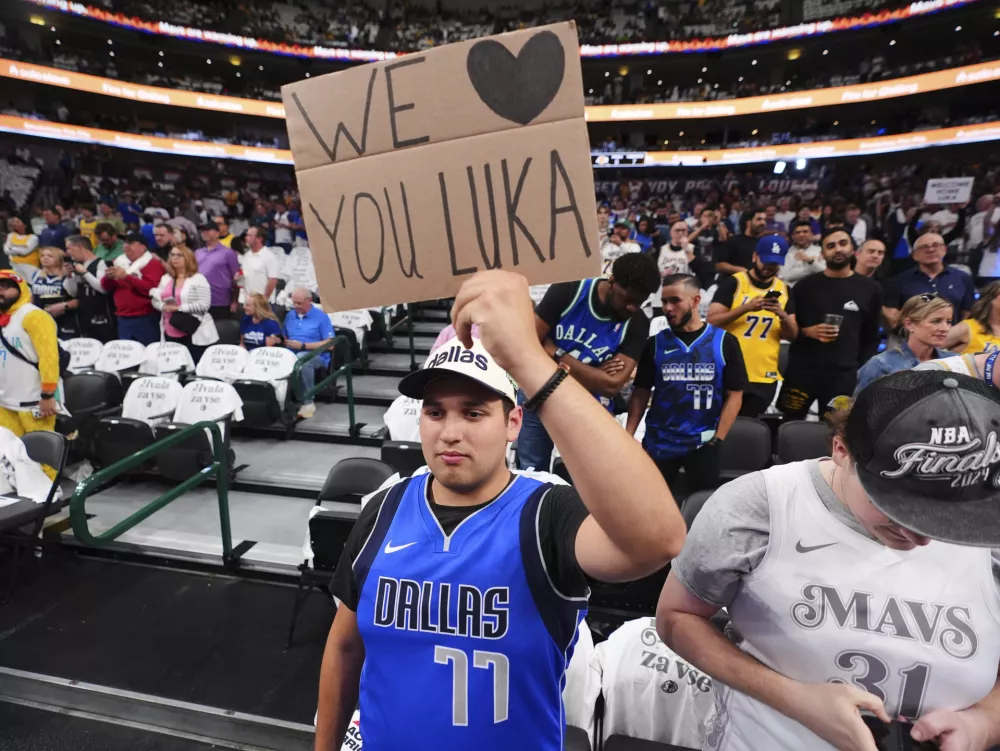 Cole Dhurandhar of Plano, Texas, holds up a sign that refers to Los Angeles Lakers' Luka Doncic before an NBA basketball game against the Dallas Mavericks in Dallas, Wednesday, April 9, 2025. (AP Photo/LM Otero) / Foto: Lm Otero