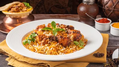 A closeup of chicken biryani dish served on a wooden table / Foto: Wirestock
