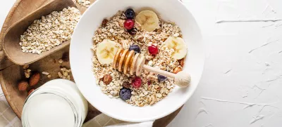 A bowl of dry granola and muesli served with fresh fruit and nuts. Traditional Oatmeal plate. Healthy food, diet. Top view. / Foto: Dulezidar