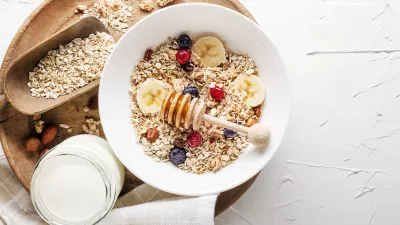 A bowl of dry granola and muesli served with fresh fruit and nuts. Traditional Oatmeal plate. Healthy food, diet. Top view. / Foto: Dulezidar
