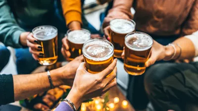 Group of friends drinking and toasting glass of beer at brewery pub restaurant- Happy multiracial people enjoying happy hour with pint sitting at bar table- Youth Food and beverage lifestyle concept / Foto: Nicolas Micolani