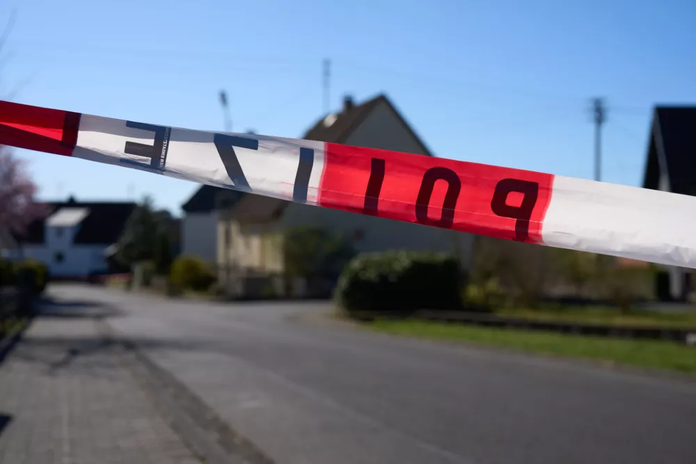 07 April 2025, Weitefeld: A road is cordoned off with police tape as the investigation into the violent attack that left three family members dead in the Westerwald continues. Authorities are working to determine the circumstances surrounding the incident. Photo: Thomas Frey/dpa