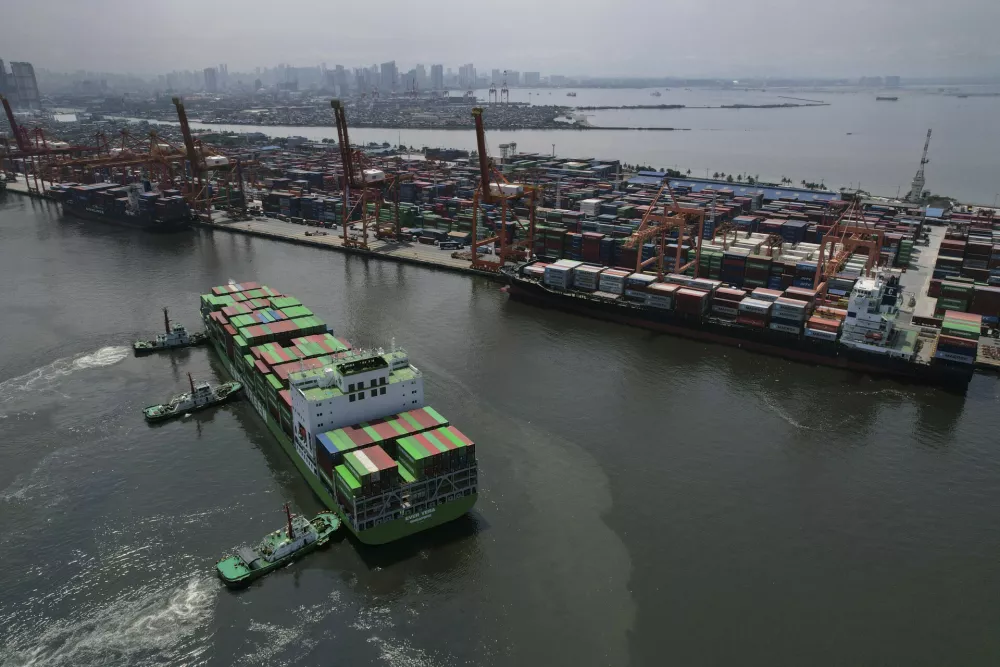Tugboats assist a container ship as it prepares to dock at the Manila International Container Terminal at the Philippine capital on Tuesday, April 8, 2025. (AP Photo/Aaron Favila)