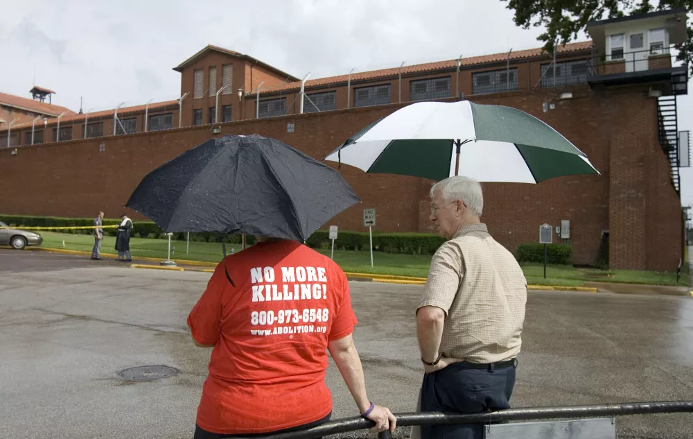 Dave Atwood, right, founder of Texas Coalition to Abolish the Death Penalty, waits in the rain with Kelly Epstein to protest the scheduled execution of Johnny Ray Conner, Wednesday, Aug. 22, 2007 at the Huntsville Unit in Huntsville, Texas. The Texas execution was the 400th in the United States' most active death penalty state since the U.S. Supreme Court allowed capital punishment to resume in 1976. (AP Photo/Paul Zoeller)
