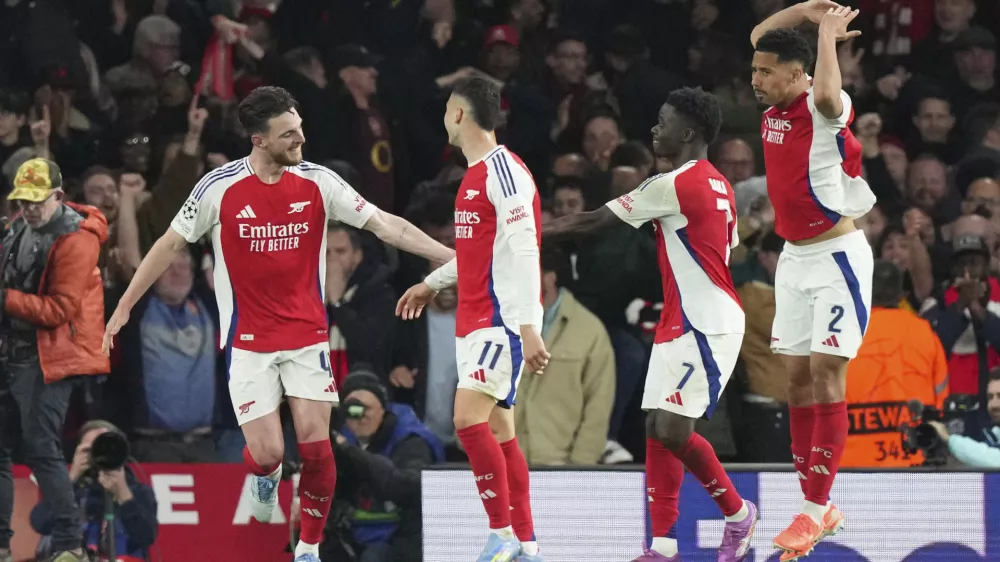 Arsenal's Declan Rice, left, celebrates after scoring his side's second goal during the Champions League quarterfinal first leg soccer match between Arsenal and Real Madrid at the Emirates Stadium in London, Tuesday, April 8, 2025. (AP Photo/Frank Augstein)