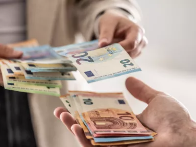 denar, plača, evro, evri, gotovina Businesswoman's hands exchanging euro banknotes, closeup shot. / Foto: Marianvejcik