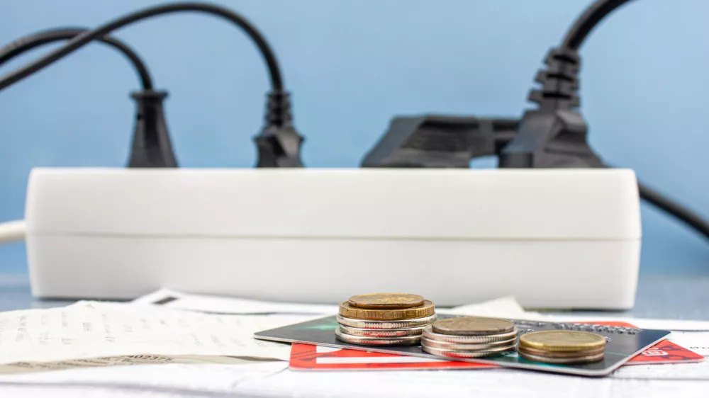 The Money, bank credit cards and electricity bills on the background of an electrical outlet. Electricity debts, the concept of rising electricity prices. / Foto: Bin Kontan