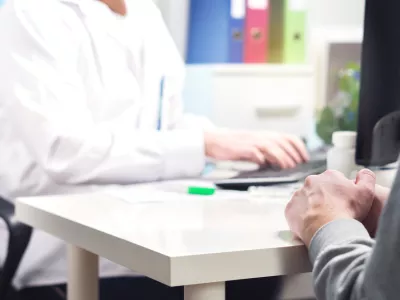 Doctor and patient in appointment, visit or meeting in hospital office or emergency room. Physician or nurse writing prescription, instructions, medical record or data with computer. / Foto: Tero Vesalainen