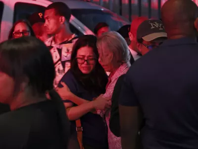 Relatives of missing people embrace while waiting at the National Institute of Forensic Pathology after the roof collapsed at Jet Set nightclub during a merengue concert in Santo Domingo, Dominican Republic, Tuesday, April 8, 2025. (AP Photo/Ricardo Hernandez)