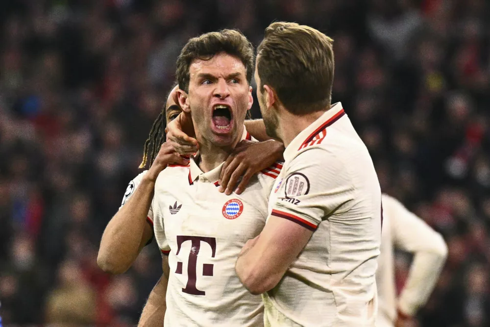 Bayern's Thomas Mueller celebrates with teammates after scoring his side's opening goal during the Champions League quarterfinals first leg soccer match between FC Bayern Munich and Inter Milan, at the Allianz Arena in Munich, Germany, Tuesday, April 8, 2025. (Tom Weller/dpa via AP)