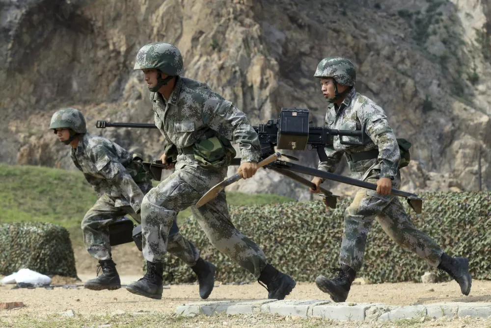 Members of People's Liberation Army (PLA) coastal defence force carry a machine gun during a drill to mark the upcoming 87th Army Day at a military base in Qingdao, Shandong province July 29, 2014. The PLA Army Day falls on August 1 every year. Chinese President Xi Jinping has pledged to strike hard against graft in the military, urging soldiers to banish corrupt practices and ensure their loyalty to the ruling Communist Party, state media reported on Friday. Picture taken July 29, 2014. REUTERS/Stringer (CHINA - Tags: MILITARY POLITICS ANNIVERSARY) CHINA OUT. NO COMMERCIAL OR EDITORIAL SALES IN CHINA