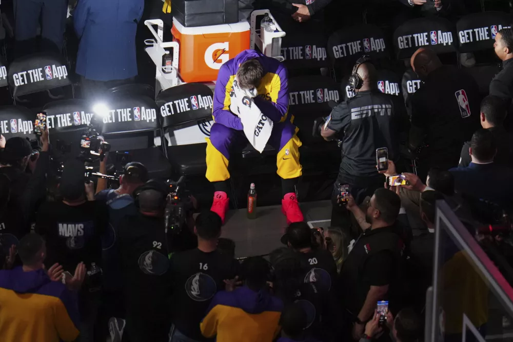 An emotional Los Angeles Lakers' Luka Doncic puts a towel to his face as a vide tribute is played in the arena thanking the former Dallas Mavericks player before an NBA basketball game in Dallas, Wednesday, April 9, 2025. (AP Photo/Julio Cortez)