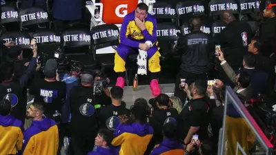 Los Angeles Lakers' Luka Doncic looks up at a large video board paying a tribute to the former Dallas Mavericks player before an NBA basketball game in Dallas, Wednesday, April 9, 2025. (AP Photo/Julio Cortez)