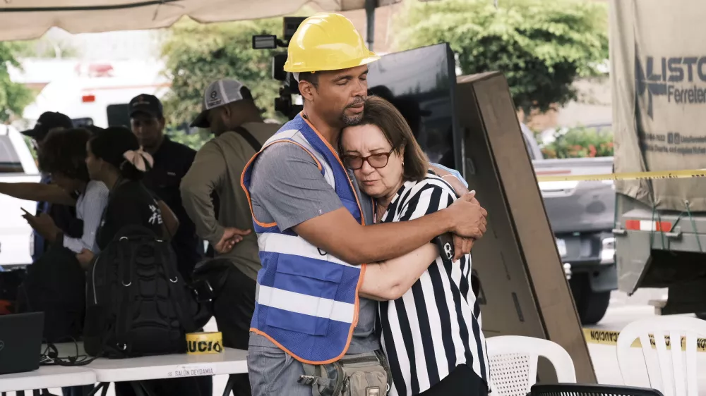 A rescue worker comforts a woman during the search for survivors at the Jet Set nightclub after its roof collapsed two nights prior during a merengue concert in Santo Domingo, Dominican Republic, Wednesday, April 9, 2025. (AP Photo/Ricardo Hernandez)