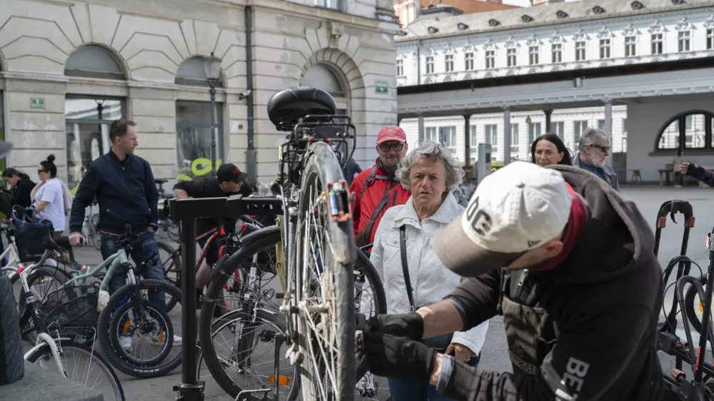 Klemen Mavec se je lotil mazanja verige na kolesu, ki ga je za sina na servis pripeljala Ljubljančanka. Foto:&nbsp;Nik Erik Neubauer