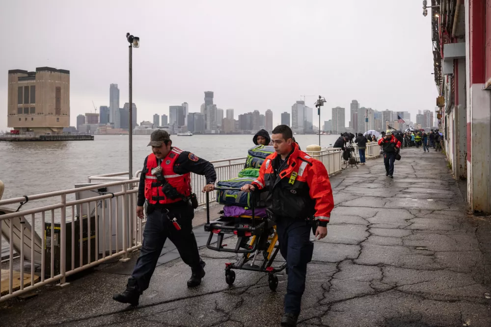 The New York City Fire Department (FDNY) personnels carry a stretcher at Pier 40, where a helicopter went down in the Hudson River between Manhattan and the New Jersey waterfront, Thursday, April 10, 2025, in New York. (AP Photo/Yuki Iwamura)