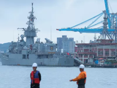 Two staff members look on as navy ships park at the port, as China announces new military drills around Taiwan, in Keelung, Taiwan May 23, 2024. REUTERS/Ann Wang