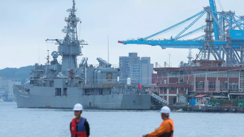Two staff members look on as navy ships park at the port, as China announces new military drills around Taiwan, in Keelung, Taiwan May 23, 2024. REUTERS/Ann Wang