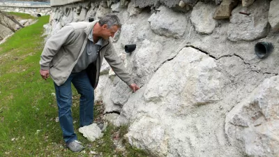 Boris &Scaron;tupar pokaže na vidne razpoke, ki jih je na povsem novi &scaron;karpi naredila teža tovornjakov, svoje pa je dodala &scaron;e voda. Foto: Tomaž Skale