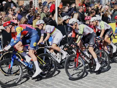 Slovenia's Tadej Pogacar, of the UAE Team Emirates XRG, second left, rides with the pack through the historical center of Oudenaarde, Belgium, during the Tour of Flanders on Sunday, April 6, 2025. (AP Photo/Geert Vanden Wijngaert)