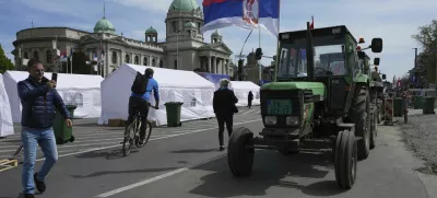 Tractors are parked in front of the Serbian parliament building ahead of a big counter-opposition protest rally planned to be staged over the weekend in downtown Belgrade, Serbia, Friday, April 11, 2025. (AP Photo/Darko Vojinovic)