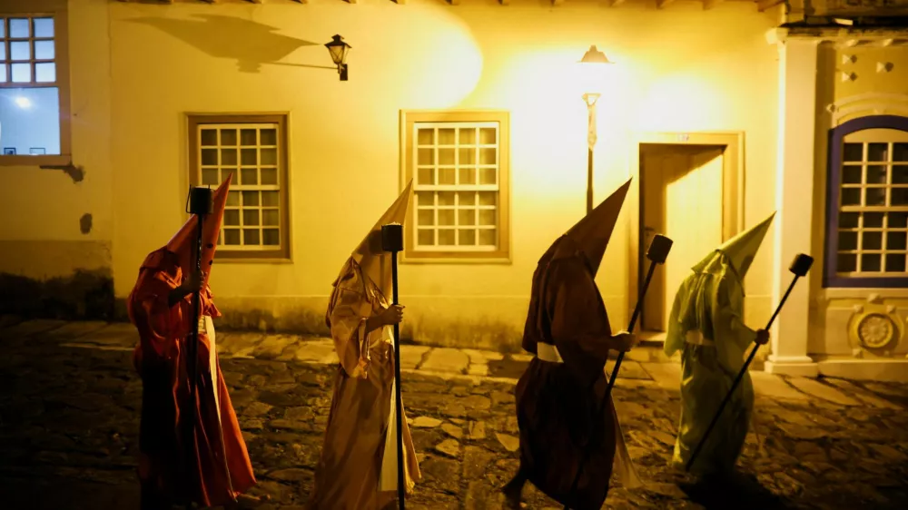 Hooded Catholic faithful walk in the Torch Procession, known as Fogareu, during the Holy Week in Goias, State of Goias, Brazil April 16, 2025. REUTERS/Adriano Machado   TPX IMAGES OF THE DAY