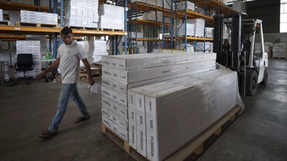 An employee inspects stocks before they are loaded onto a container for shipping to the U.S. at Corporate Specialist's furniture factory on the outskirts of Muar, in Johor state of Malaysia, Friday, April 11, 2025. (AP Photo/Vincent Thian)