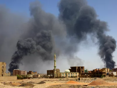 FILE PHOTO: A man walks while smoke rises above buildings after aerial bombardment, during clashes between the paramilitary Rapid Support Forces and the army in Khartoum North, Sudan, May 1, 2023. REUTERS/Mohamed Nureldin Abdallah//File Photo