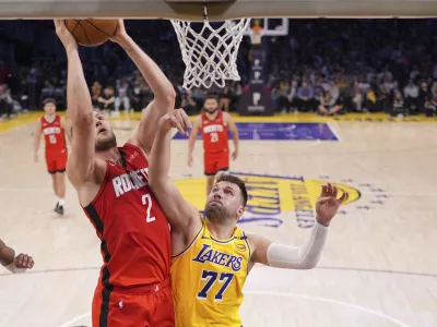 Houston Rockets center Jock Landale, left, shoots as Los Angeles Lakers guard Luka Doncic defends during the second half of an NBA basketball game Friday, April 11, 2025, in Los Angeles. (AP Photo/Mark J. Terrill)