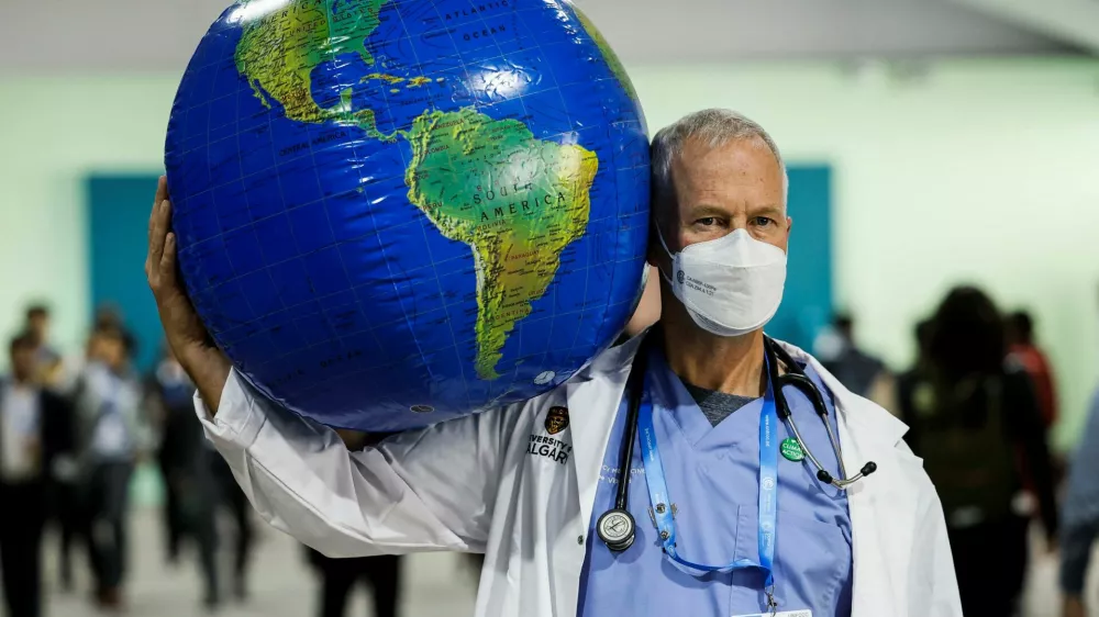 Emergency physician Joe Vipond, a member of Canadian Association of Physicians for the Environment (CAPE), poses for photographers with a model of the globe as he stands for support of climate agenda during the United Nations Climate Change Conference (COP29), in Baku, Azerbaijan November 15, 2024. REUTERS/Maxim Shemetov
