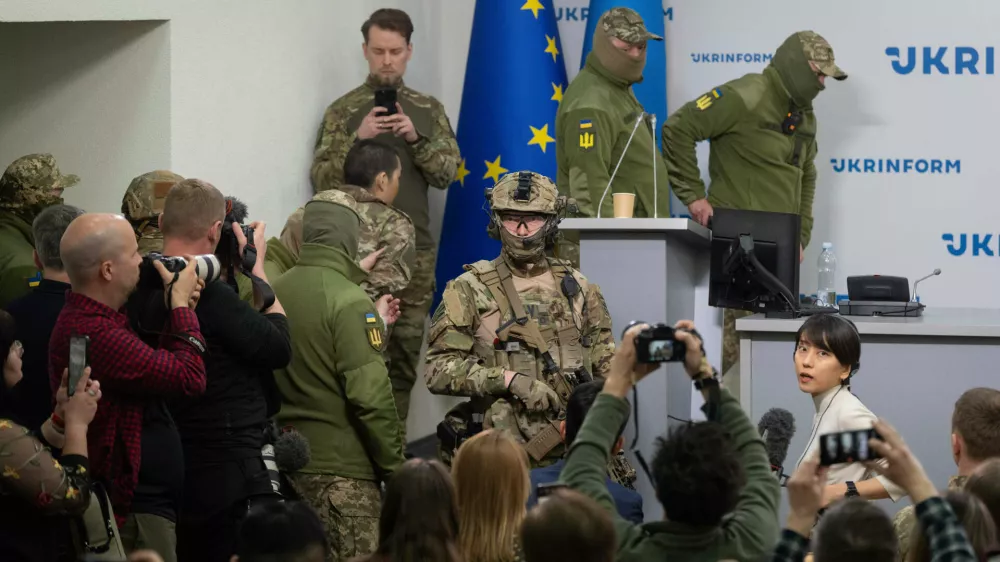 Ukrainian security officers escort a Chinese national, center-left, back to camera, who was captured by Ukrainian forces while fighting on the Russian side, to a press conference in Kyiv, Ukraine, Monday, April 14, 2025. (AP Photo/Efrem Lukatsky)