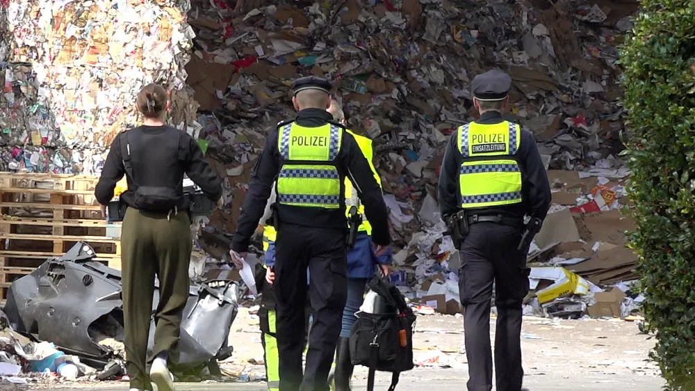 14 April 2025, Hamburg: Police officers are investigating the site of a recycling company where a dead man was found. Photo: Bodo Marks/dpa
