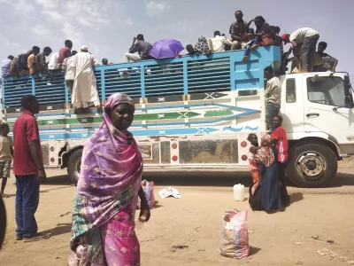 FILE - People board a truck as they leave Khartoum, Sudan, on June 19, 2023. (AP Photo, File)