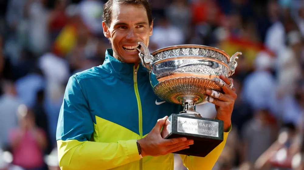 FILE PHOTO: Tennis - French Open - Roland Garros, Paris, France - June 5, 2022 Spain's Rafael Nadal bites the trophy to celebrate winning the men's singles final against Norway's Casper Ruud REUTERS/Yves Herman/File Photo