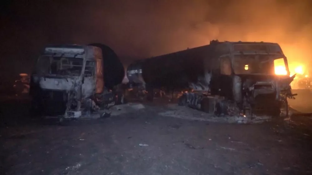 Fire and smoke rise next to charred vehicles following, what Al Masirah TV said, was a U.S. strike on the Ras Isa fuel port, Yemen, in this screengrab from a handout video released on April 18, 2025. Al-Masirah TV /Handout via REUTERS  THIS IMAGE HAS BEEN SUPPLIED BY A THIRD PARTY. NO RESALES. NO ARCHIVES