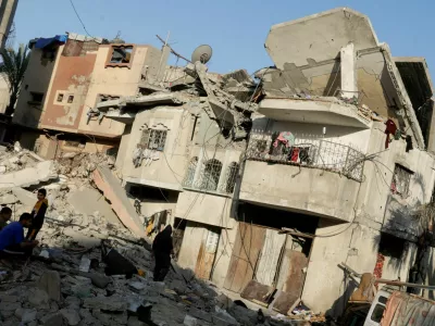 Palestinians gather at the site of an Israeli strike on a house, in Khan Younis in the southern Gaza Strip April 19, 2025. REUTERS/Hatem Khaled