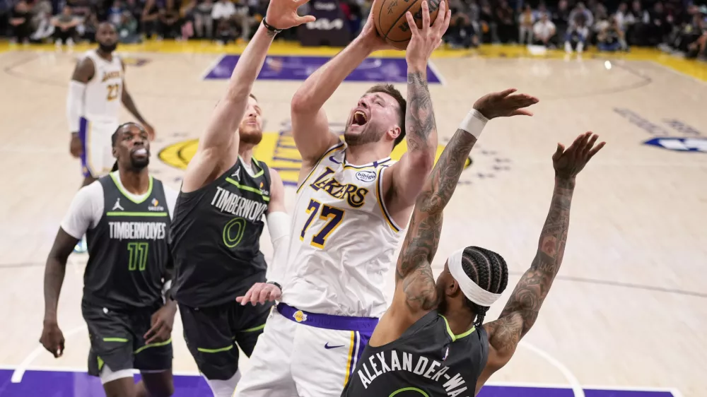 Los Angeles Lakers guard Luka Doncic (77) shoots as Minnesota Timberwolves guard Nickeil Alexander-Walker (9), guard Donte DiVincenzo (0) and center Naz Reid (11) defend during the second half in Game 1 of an NBA first-round playoff series Saturday, April 19, 2025, in Los Angeles. (AP Photo/Mark J. Terrill)