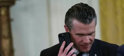 FILE PHOTO: U.S. Defense Secretary Pete Hegseth uses a phone as he attends a joint press conference of U.S. President Donald Trump and Israeli Prime Minister Benjamin Netanyahu in the East Room at the White House in Washington, U.S., February 4, 2025. REUTERS/Leah Millis/File Photo