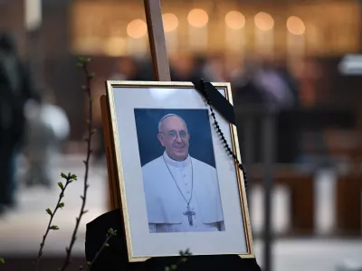 22 April 2025, Hesse, Frankfurt/Main: A photograph of Pope Francis, adorned with a mourning ribbon, is displayed on an easel at the altar of St. Bartholomew's Cathedral. The Argentine pontiff, who led the Catholic Church from 2013, passed away on Easter Monday at the age of 88, leaving a lasting legacy and a profound impact on millions around the world. Photo: Arne Dedert/dpa - ATTENTION: editorial use only in connection with the latest coverage and only if the credit mentioned above is referenced in full