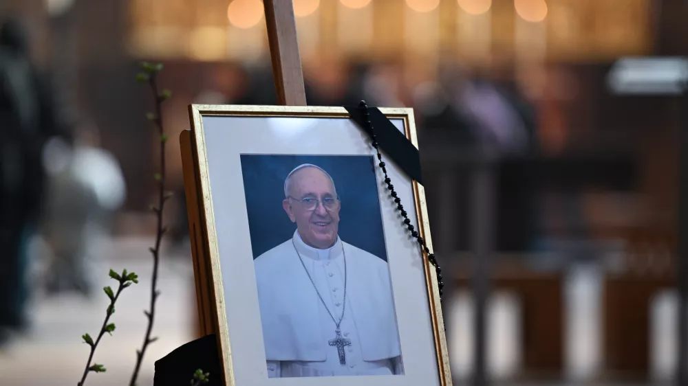 22 April 2025, Hesse, Frankfurt/Main: A photograph of Pope Francis, adorned with a mourning ribbon, is displayed on an easel at the altar of St. Bartholomew's Cathedral. The Argentine pontiff, who led the Catholic Church from 2013, passed away on Easter Monday at the age of 88, leaving a lasting legacy and a profound impact on millions around the world. Photo: Arne Dedert/dpa - ATTENTION: editorial use only in connection with the latest coverage and only if the credit mentioned above is referenced in full