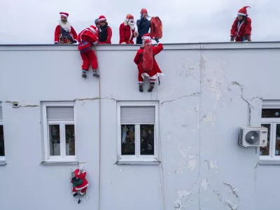 A drone view shows volunteers, dressed in Santa Claus costumes, rappelling from the roof of Children's Hospital Srebrnjak to bring gifts to the children, in Zagreb, Croatia December 23, 2024. REUTERS/Antonio Bronic