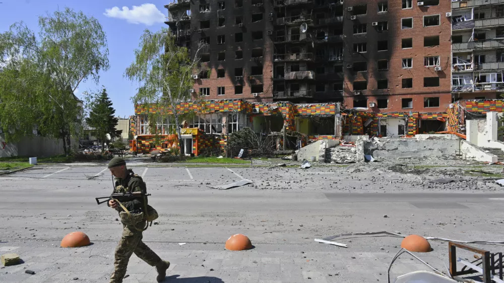 A Ukrainian soldier walks past damaged buildings in central Pokrovsk, the site of the heaviest battles with the Russian troops in the Donetsk region, Ukraine, Wednesday, April 23, 2025. (AP Photo/Michael Shtekel)