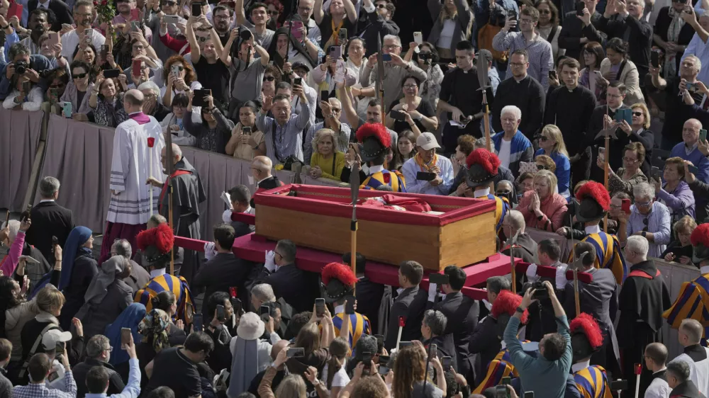 The body of Pope Francis is carried through St. Peter's Square to St. Peter's Basilica at the Vatican, Wednesday, April 23, 2025, where he will lie in state for three days. (AP Photo/Markus Schreiber)