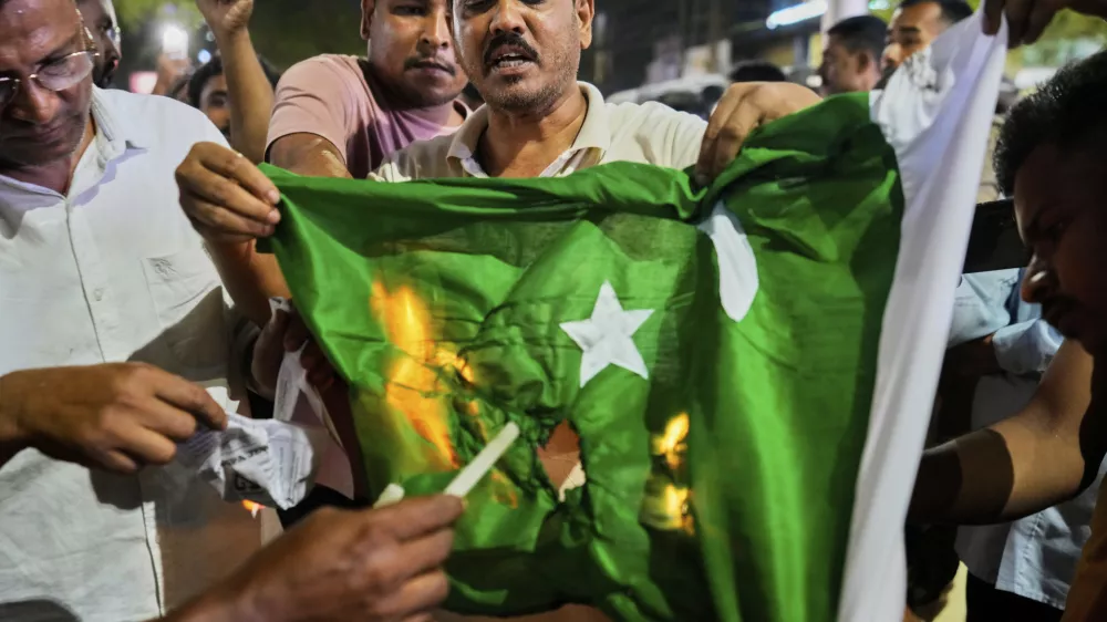 People burn a Pakistani flag in protest against the killing of tourists by militants a day after militants indiscriminately opened fire on tourists near Pahalgam in Indian controlled Kashmir, in Guwahati, India, Wednesday, April 23, 2025. (AP Photo/Anupam Nath)
