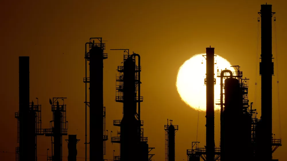 FILE - The CHS oil refinery is silhouetted against the setting sun, Sept. 28, 2024, in McPherson, Kan. (AP Photo/Charlie Riedel, file)