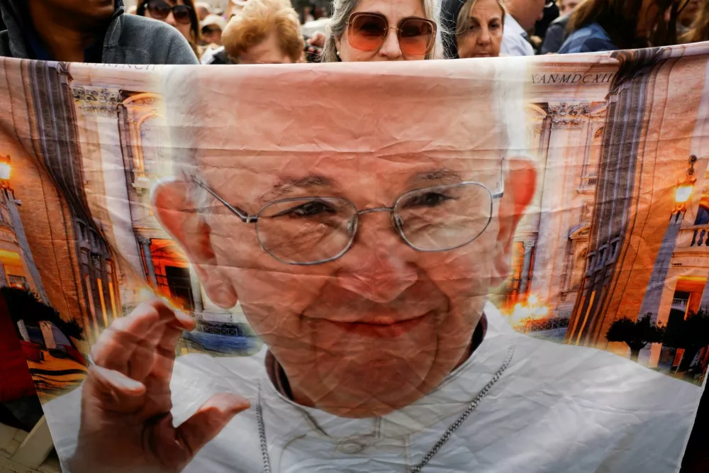 Maricarmen Gallegos, from Mexico, displays a banner with the image of Pope Francis ahead of his funeral Mass in St. Peter's Square at the Vatican, April 26, 2025. REUTERS/Susana Vera