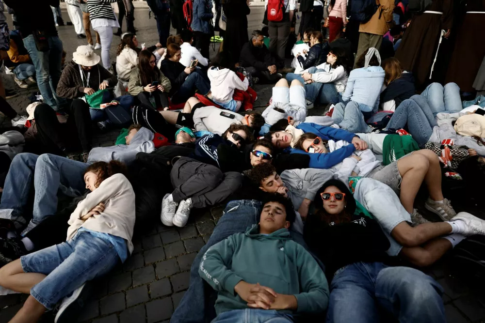 People gather, ahead of the funeral Mass of Pope Francis at St. Peter's Square, at the Vatican, April 26, 2025. REUTERS/Matteo Minnella