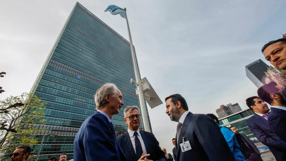 Syrian Foreign Minister Asaad Hassan al-Shibani speaks with UN Special Envoy for Syria, Geir Otto Pedersen, as they attend the raising ceremony of the new Syrian government flag, at United Nations Headquarters in New York, U.S., April 25, 2025. REUTERS/Eduardo Munoz